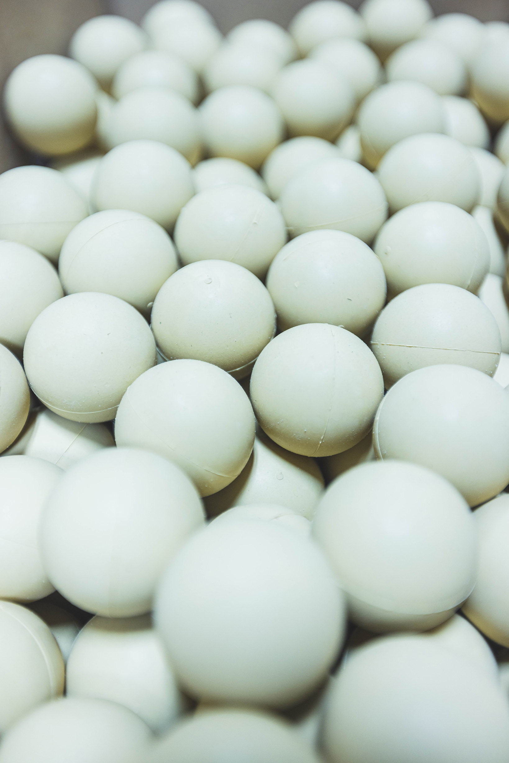 Close-up of many white ping pong balls scattered together.